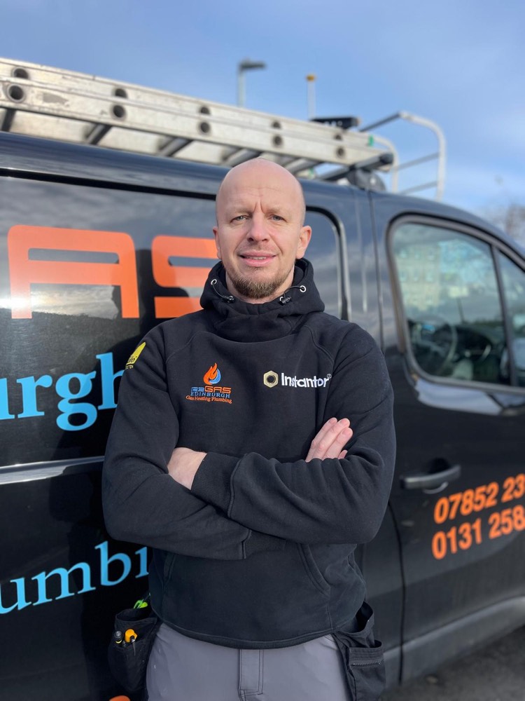 Jakub, a 123-Gas Edinburgh heating engineer, standing in front of the branded company van