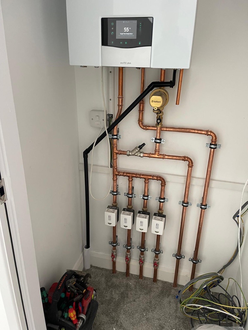 A Vaillant boiler installed above a four-zone underfloor heating manifold
