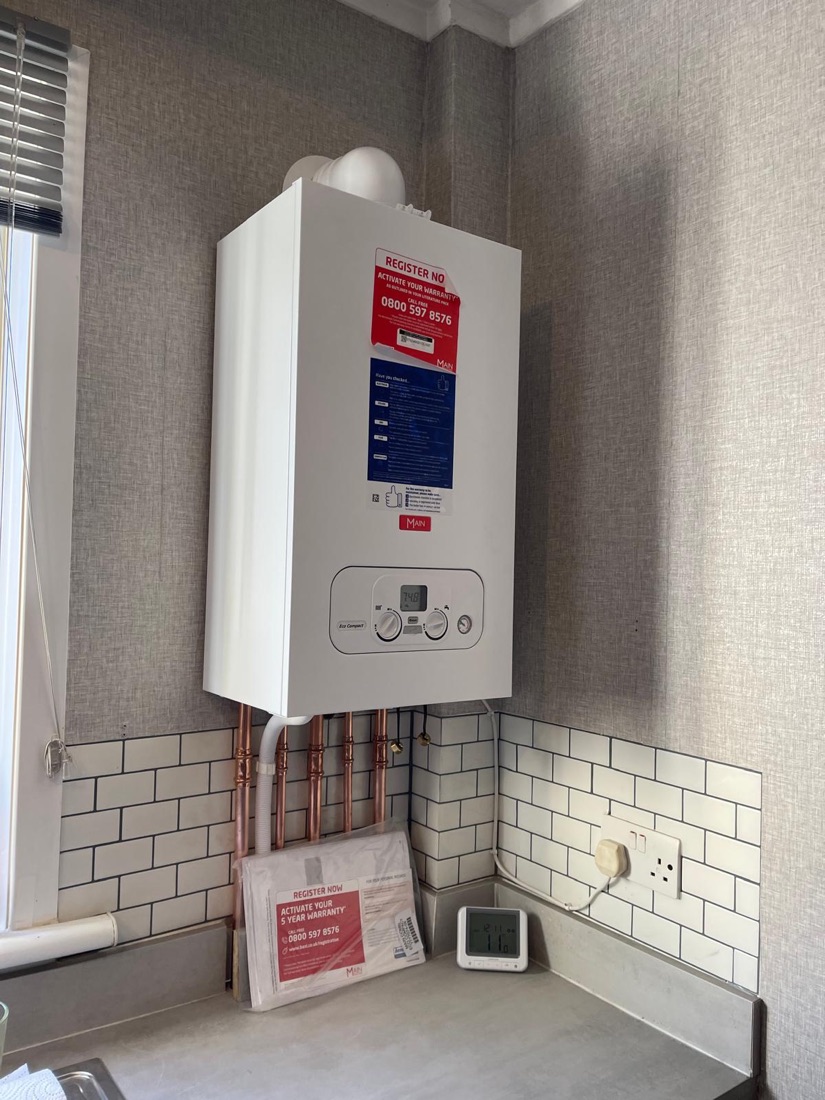 A Main combi boiler installed in a kitchen corner above a tiled splashback